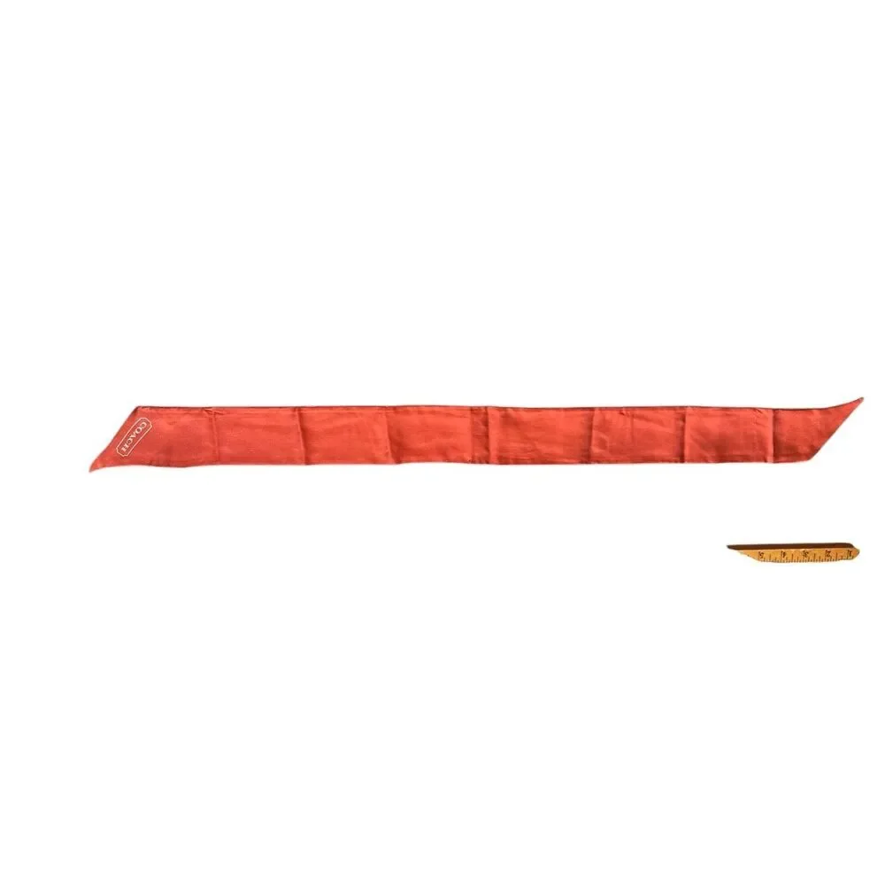 COACH silk twilly scarf orange poppy and tan signature Cs background